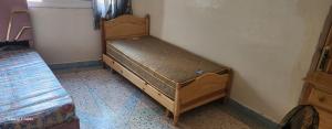 a small bed in a corner of a room at Dar imzouren al quods in Oulad Akkou
