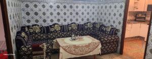 a couch with a table in a room at Dar imzouren al quods in Oulad Akkou