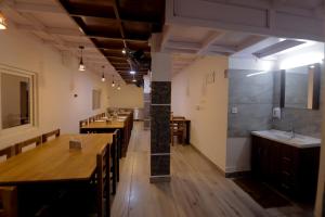 Himasailam Pool Resort Vagamon في فاغامون: غرفة طعام مع طاولات وكراسي خشبية