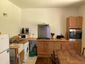 Una cocina con gabinetes de madera y una mesa en ella. en Gîte Chez Chenon, en Saint-Sulpice-de-Ruffec 9 fotos más