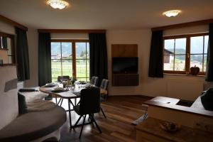 a living room with a table and chairs and a television at Alpenchalet Eiter in Arzl im Pitztal