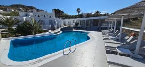 a swimming pool with chairs and a resort at Casa Bianca in Ornos