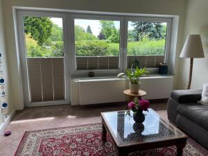 a living room with a couch and two large windows at Ferienhaus Amare mit Fasssauna, eigener Terrasse & Kamin in Bautzen