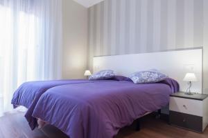 a bedroom with a purple bed with two pillows at Pensión Entreviñas in Logroño