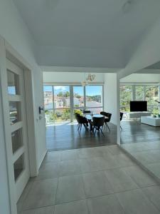 ein großes Wohnzimmer mit Tisch und Stühlen in der Unterkunft Anemoni Beach Hotel in Skiathos-Stadt