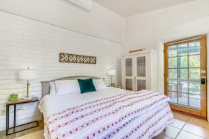 a white bedroom with a large bed and a window at Casa Paloma Studio Artsy and Airy with Hot Tub Access in Patagonia