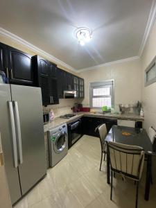a kitchen with a refrigerator and a table with chairs at luxury sea view apartment in Tangier