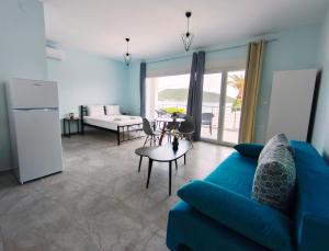 a living room with a blue couch and a table at Beachway luxury studio A B in Nea Peramos