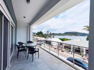 a balcony with a table and chairs and a view of the water at Beachway luxury studio A B in Nea Peramos