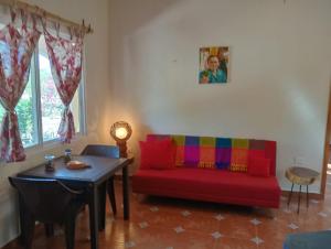 a living room with a red couch and a table at Rancho Camote - Frida 1 bedroom in Chichimilá