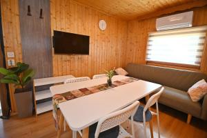 a living room with a white table and a couch at Počitniška kamp hiška Miha, Terme 3000 in Moravske Toplice