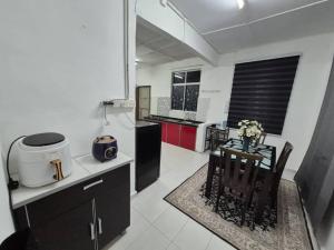 a kitchen with a small table and a counter top at Syaf Homestay in Lunas
