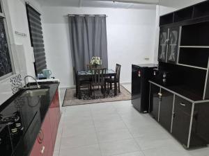 a kitchen with a table and a dining room at Syaf Homestay in Lunas