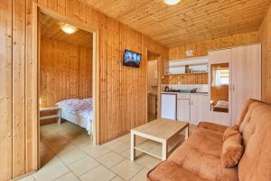 a living room with a couch and a small kitchen at Aga Domki-bezpłatny parking in Rewal