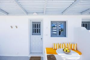 a white room with a bench and a table at Flisvos beach studios in Naxos Chora