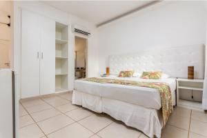 a white bedroom with a large bed in a room at Hotel Miratlantico Búzios in Búzios