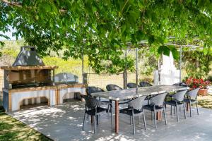 a table and chairs and a grill in a yard at Opalium Beach Front Suites in Potos