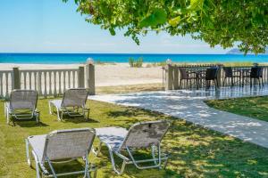 a group of chairs and tables on the beach at Opalium Beach Front Suites in Potos