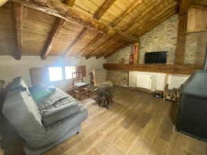 a living room with a couch and a tv at La Sabina in Terriente