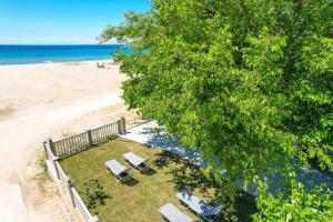 an overhead view of a beach with chairs and a tree at Opalium Beach Front Suites in Potos