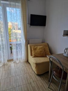 Una sala de estar con un sofá y una ventana. en Villa Oaza, en Mielno
