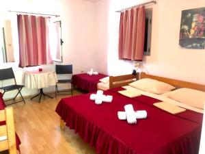 two beds with white crosses on them in a room at Apartments Vila San in Kamenari