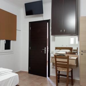 a room with a black door and a table with a chair at Porto Mesta Residence in Thasos