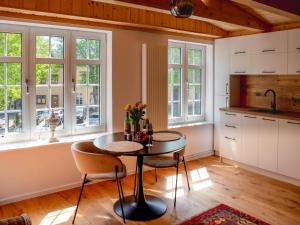 a kitchen with a table and chairs and windows at Birdhouse in Lübeck