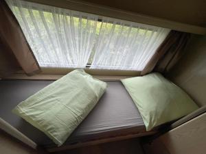 a bed in a small room with a window at Campingplatz Wohnwagen mit Vorzelt in Affing