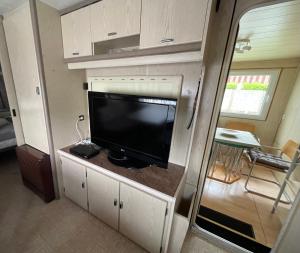 a living room with a tv in a rv at Campingplatz Wohnwagen mit Vorzelt in Affing +7 photos