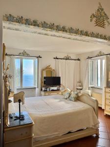 a bedroom with a large bed and a television at Villa Luxe Mare & Parco Privato in Vesima