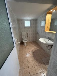 a bathroom with a toilet and a sink at Vila 23 in Dhërmi