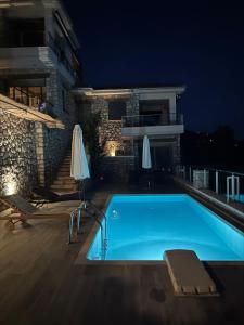 a swimming pool in front of a building at night at Lavender House 1 - Agios Nikitas in Agios Nikitas