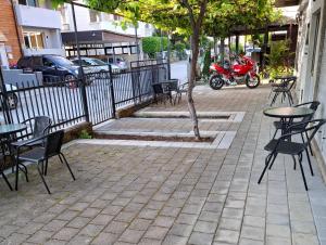 a patio with tables and chairs and a red motorcycle at Villa Kaya in Ohrid