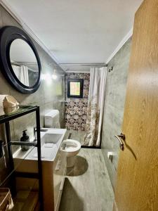 a bathroom with a toilet and a sink and a mirror at Riverstone Oasis Trebinje in Trebinje +22 photos