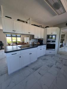 a large white kitchen with white cabinets and appliances at The Ranch Highway 55 in Debden