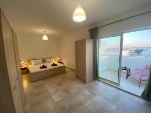 Un dormitorio con una cama y una ventana grande. en Sailsbury, en Msieraħ