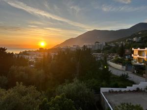 a view of a city with the sun setting at Vila 23 in Dhërmi