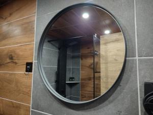 a round mirror on a wall in a bathroom at Stefanos Maisonette in Parga +71 photos