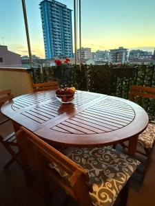 a wooden table with a bowl of fruit on a balcony at Casa Molly in Follonica