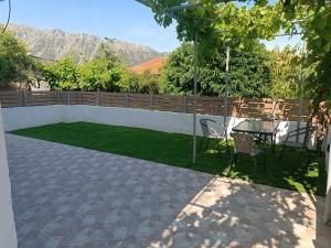a patio with a table and chairs and a lawn at Holiday Home Klimataria in Áyios Pétros