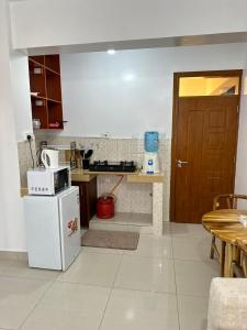 a kitchen with a white refrigerator and a table at The KONGONI PLACE in Gatunga +5 photos