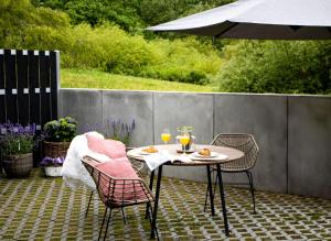 a table and chairs on a patio with an umbrella at Flussblick am Töpferberg 2 in Bad Schwartau