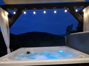 a bath tub with a view of the night at Domek na Folwarku z jacuzzi in Tarnawa Dolna +30 photos