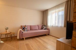 a living room with a purple couch and a window at Stilvoll sanierte Altbau-Wohnung, Dornbirn Kehlegg in Dornbirn