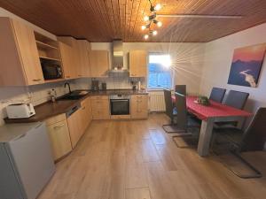 eine Küche mit einem Tisch, einem roten Tisch und Stühlen in der Unterkunft Ferienwohnung Am Lilienstein in Bad Schandau