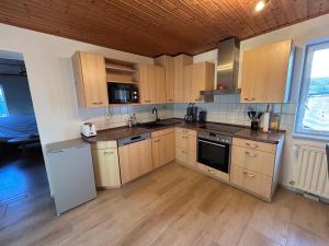 eine Küche mit Holzschränken und einem weißen Kühlschrank in der Unterkunft Ferienwohnung Am Lilienstein in Bad Schandau