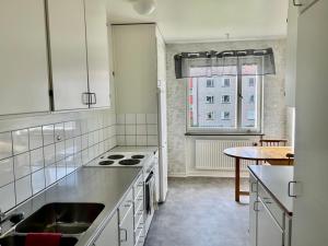 a kitchen with white cabinets and a table and a window at Två rum & kök Börstorpsgatan 13 B in Töreboda