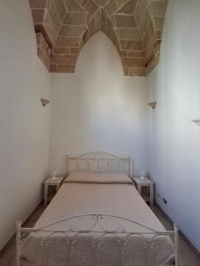 a bed in a white room with a brick ceiling at Dimora Matteotti in Nardò