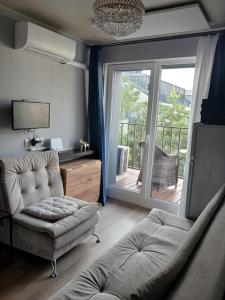 a living room with a couch and a sliding glass door at Dviejų kambarių butas in Palanga
